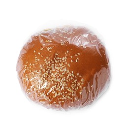 Fresh bun with plastic food wrap isolated on white, top view