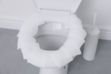 Photo of Toilet seat with paper tissues in bathroom