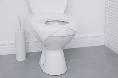 Photo of Toilet seat with paper tissues in bathroom