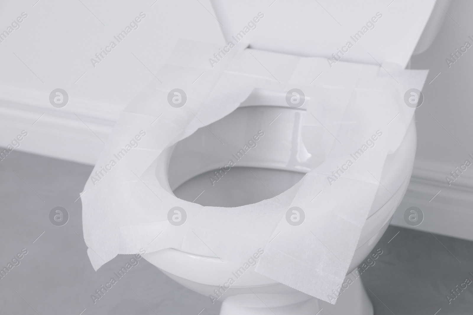 Photo of Toilet seat with paper tissues in bathroom