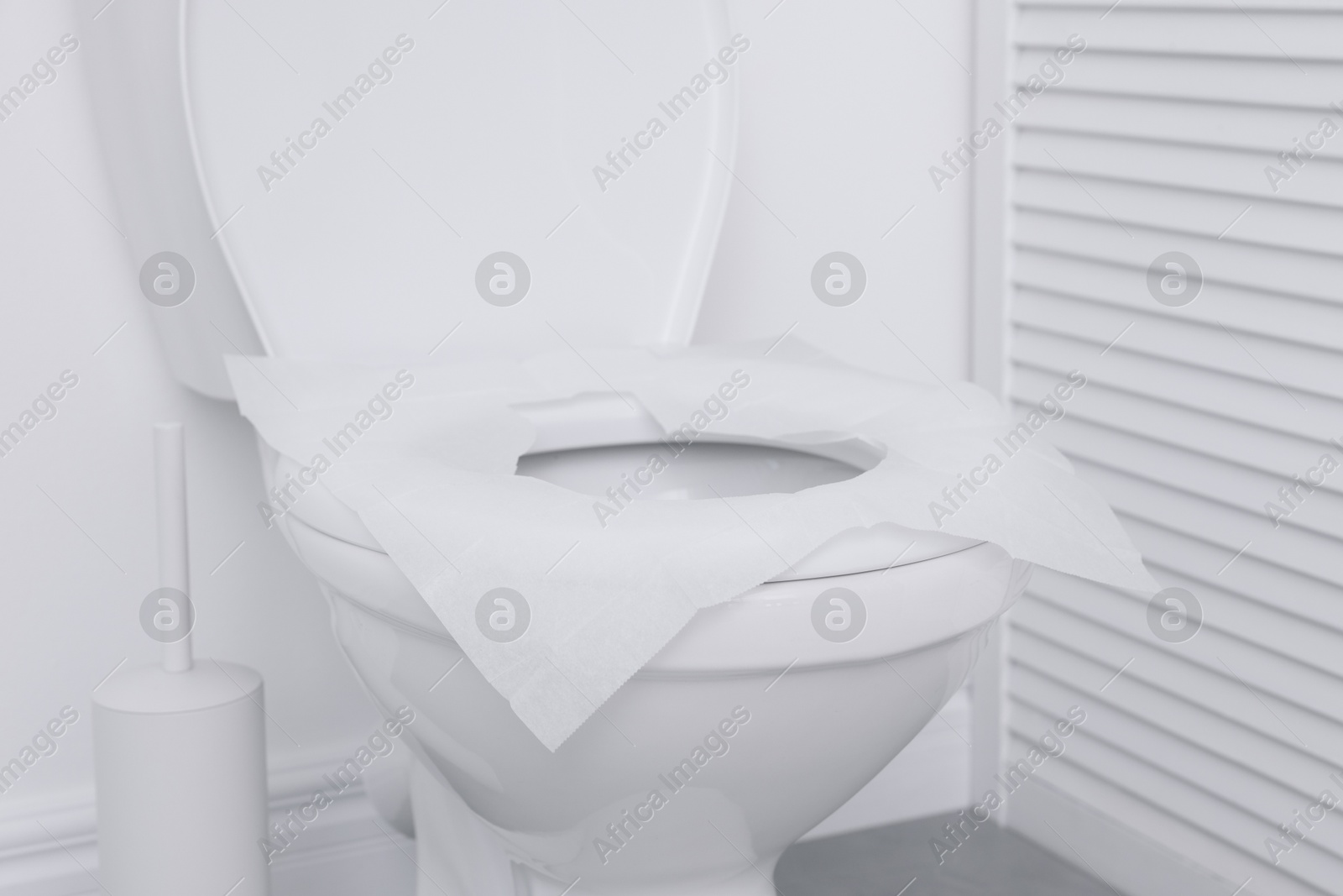 Photo of Toilet seat with paper tissues in bathroom