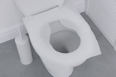 Photo of Toilet seat with paper tissues in bathroom