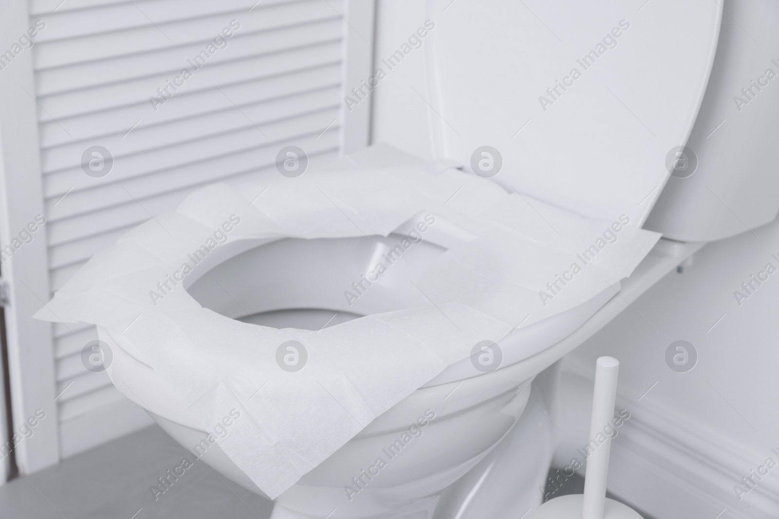 Photo of Toilet seat with paper tissues in bathroom