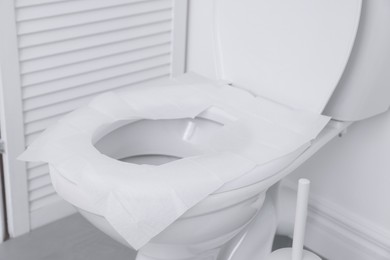 Photo of Toilet seat with paper tissues in bathroom