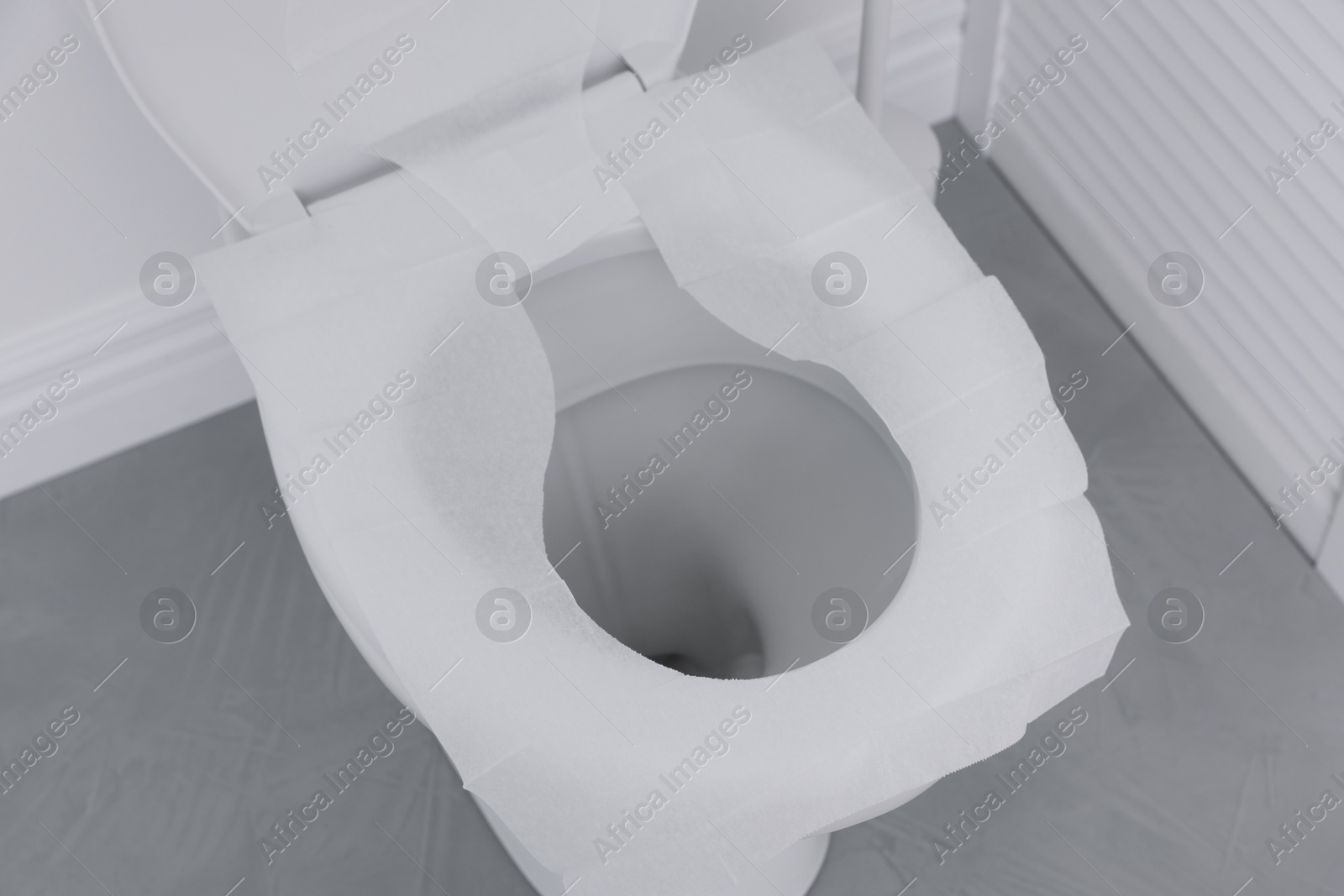 Photo of Toilet seat with paper tissues in bathroom