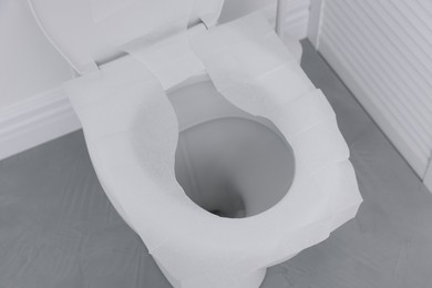 Photo of Toilet seat with paper tissues in bathroom