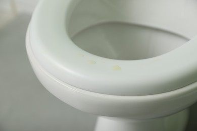 Photo of Urine drops on toilet seat in restroom, closeup