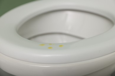 Urine drops on toilet seat in restroom, closeup