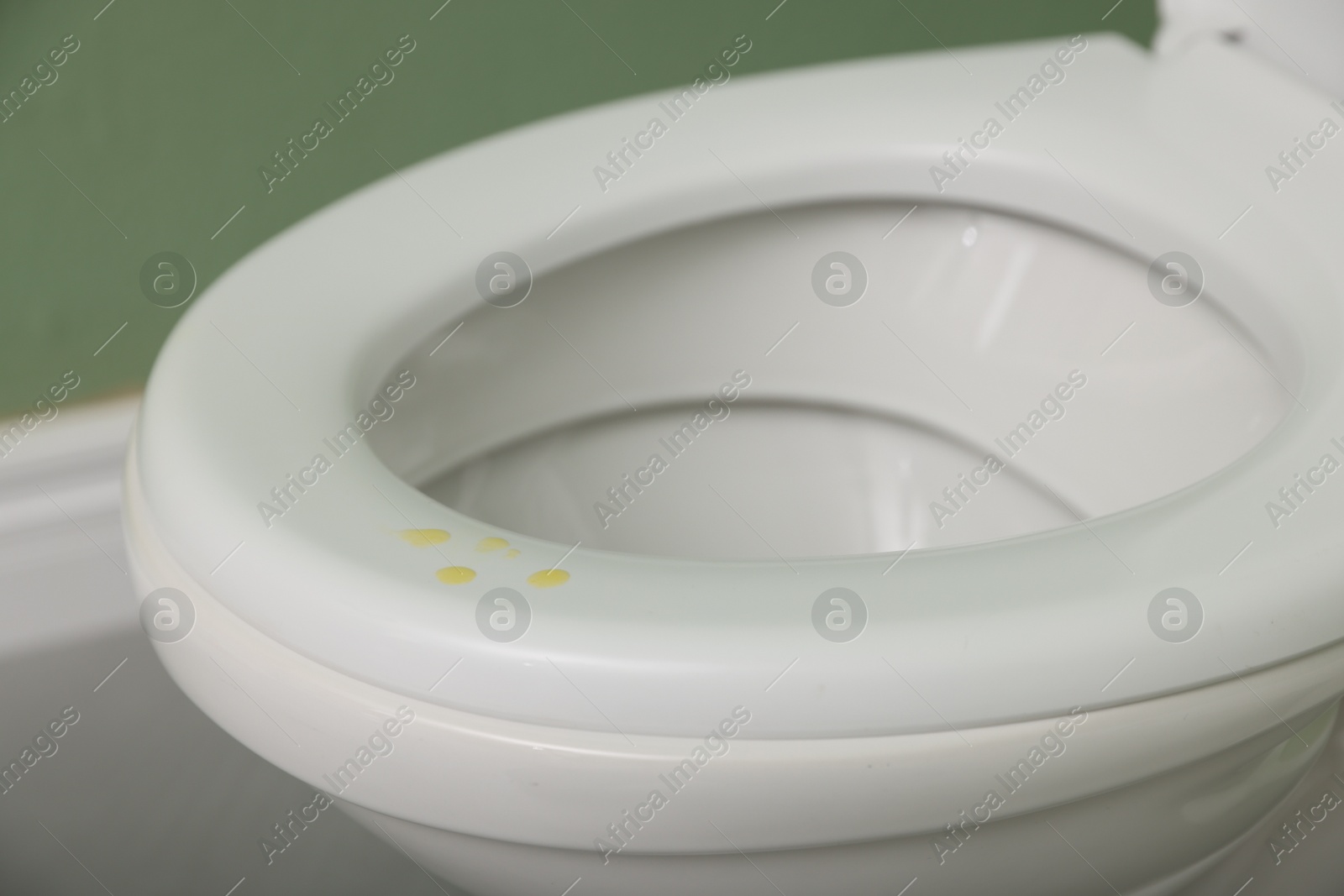 Photo of Urine drops on toilet seat in restroom, closeup