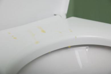 Photo of Urine drops on toilet seat in restroom, closeup