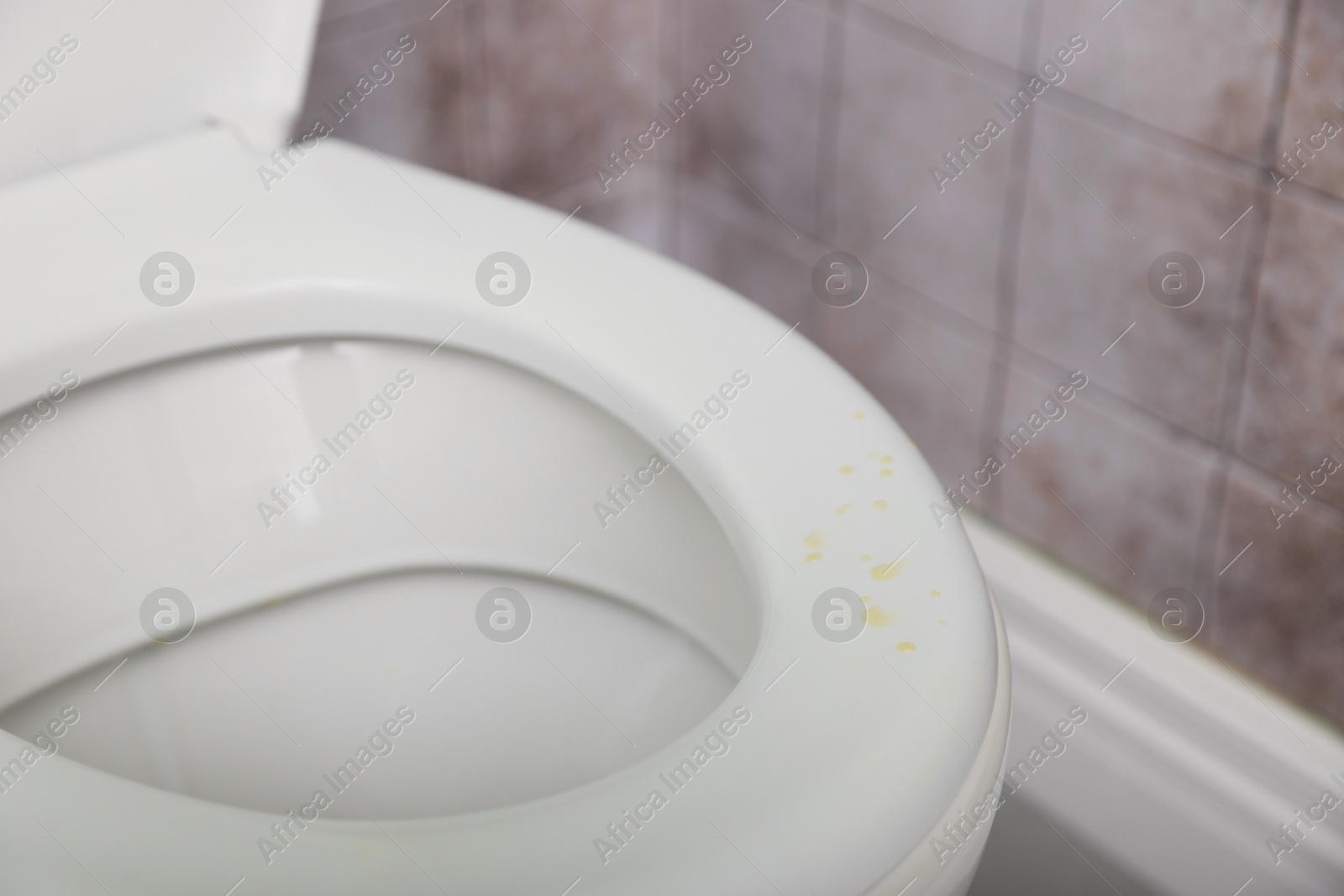 Photo of Urine drops on toilet seat in restroom, closeup