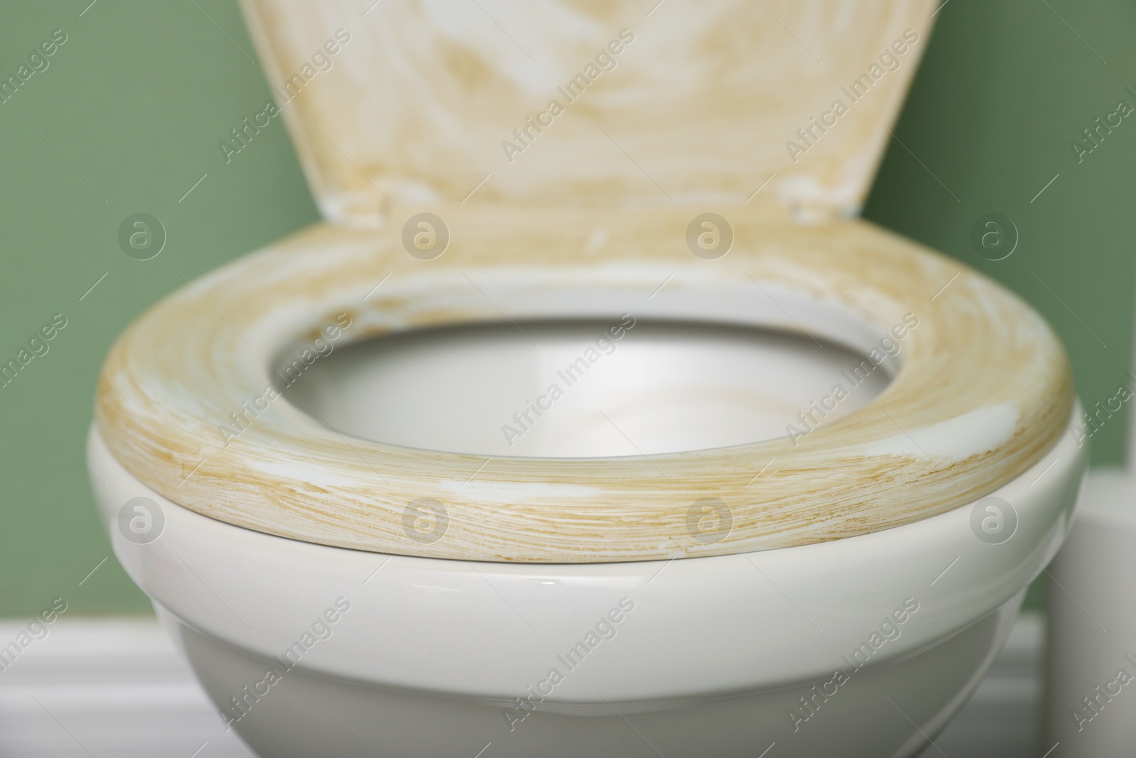 Photo of Toilet with dirty seat in public restroom, closeup