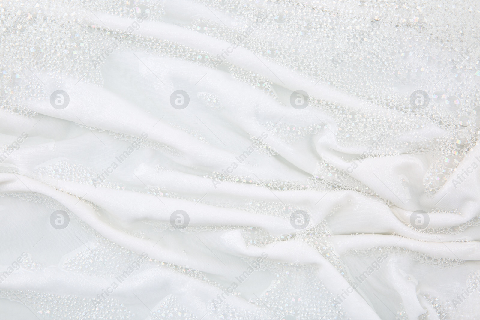 Photo of Washing laundry in water with foam, top view