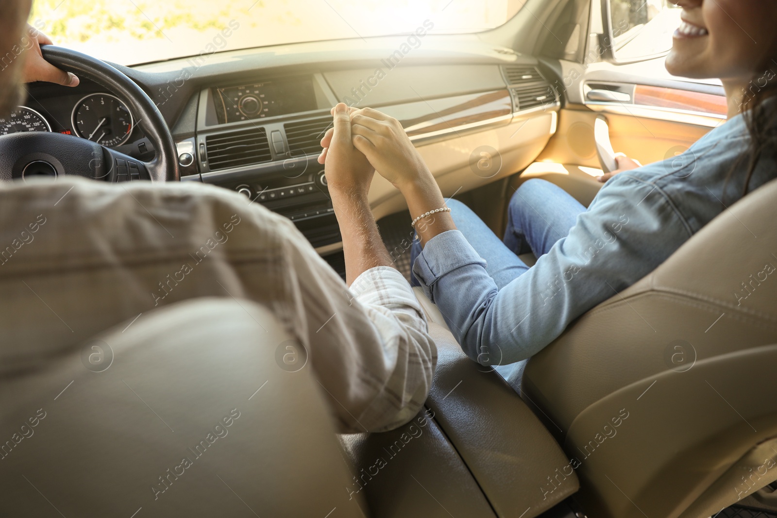 Photo of Lovely couple holding hands together while traveling by car, closeup