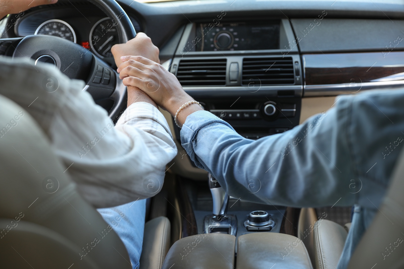 Photo of Lovely couple holding hands together while traveling by car, closeup