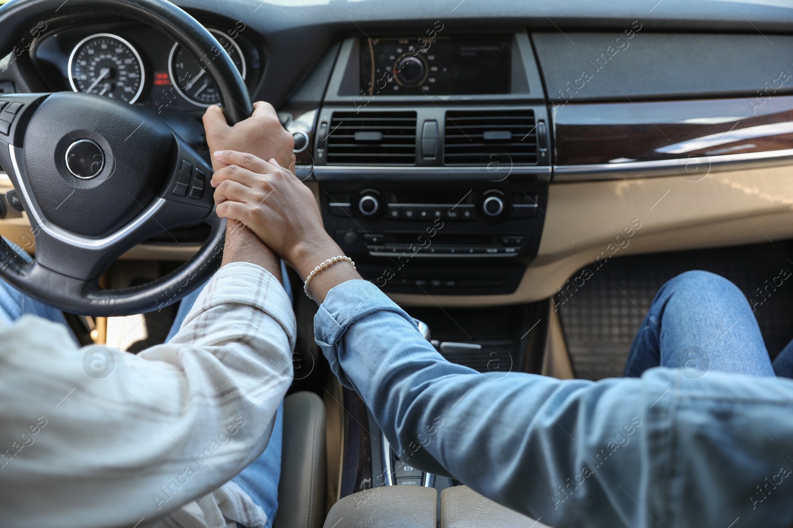 Photo of Lovely couple holding hands together while traveling by car, closeup