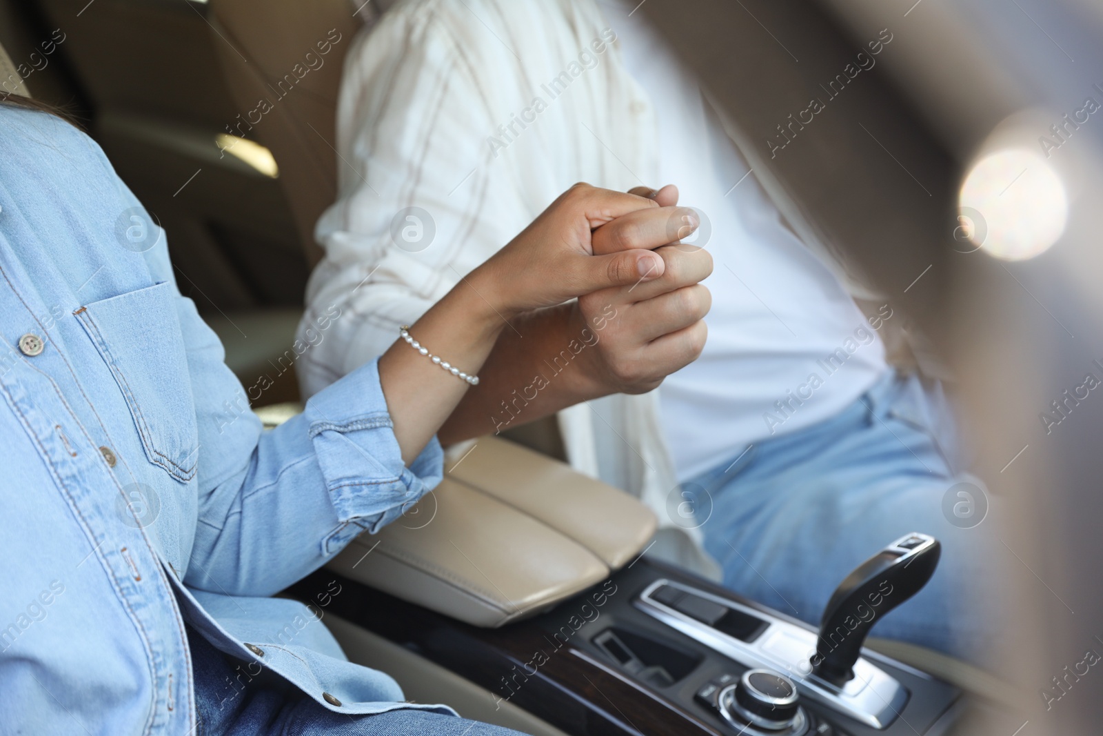 Photo of Lovely couple holding hands together while traveling by car, closeup