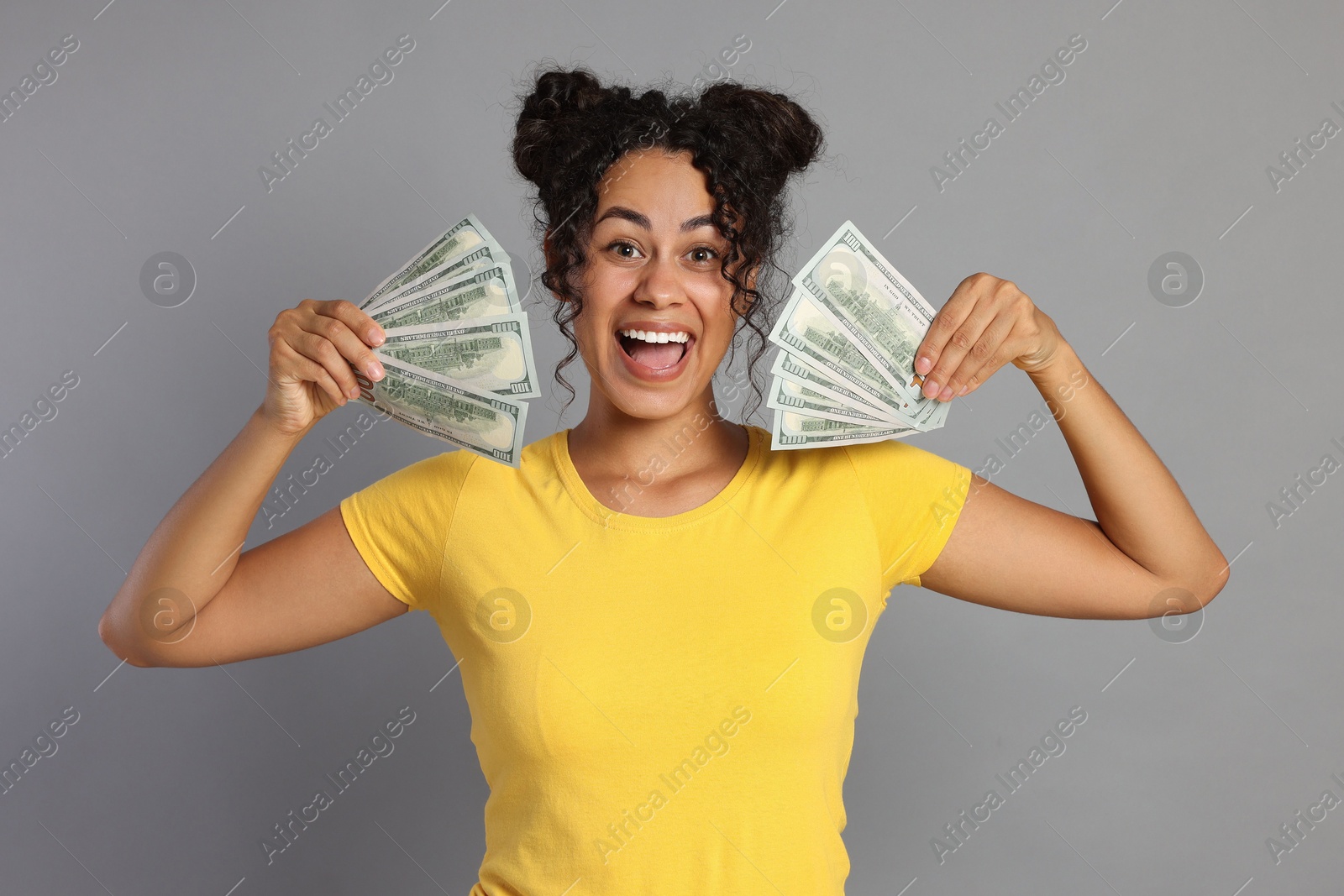 Photo of Happy woman with dollar banknotes on grey background