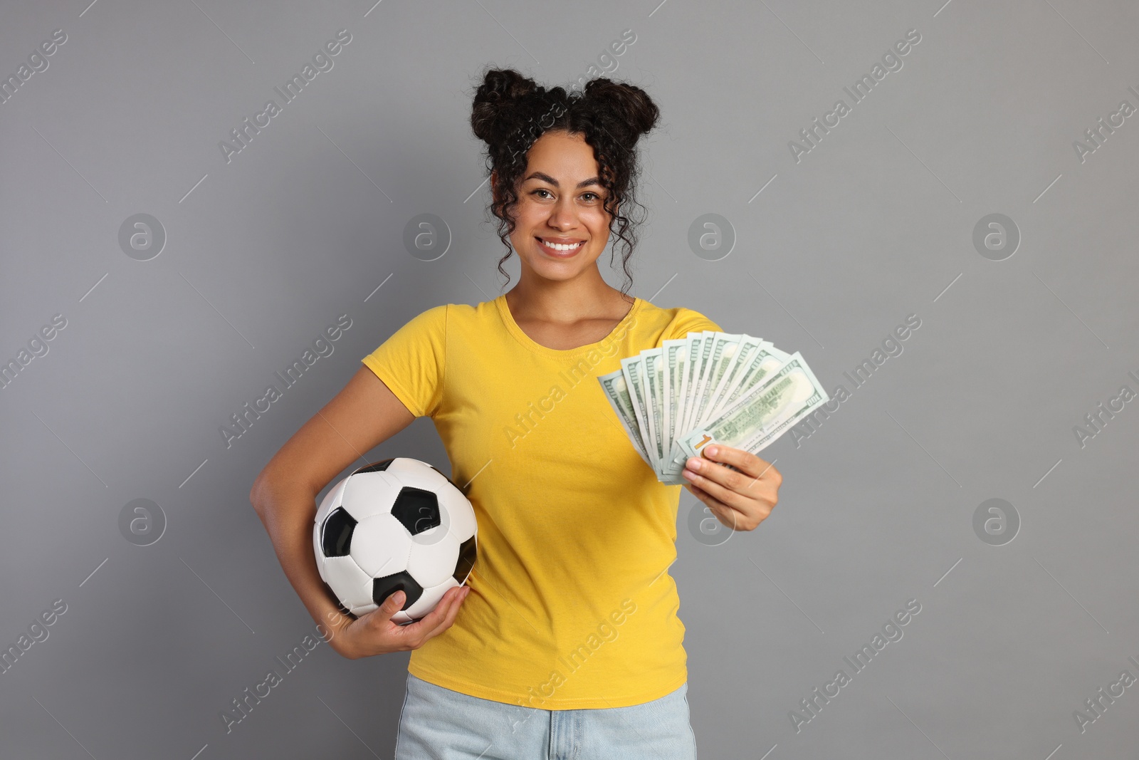 Photo of Happy woman with money and soccer ball on grey background