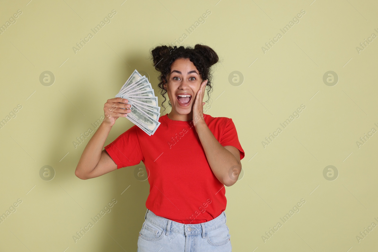 Photo of Happy woman with dollar banknotes on pale green background