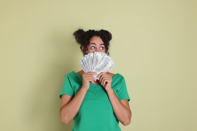 Photo of Woman with dollar banknotes on pale green background