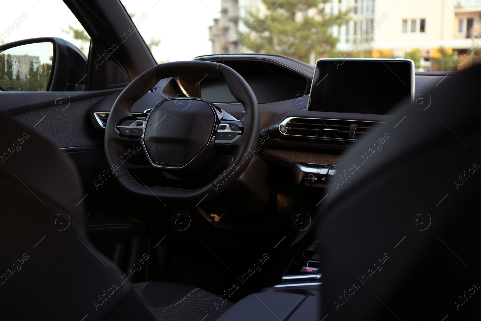 Photo of Steering wheel and dashboard inside of modern luxury car, closeup