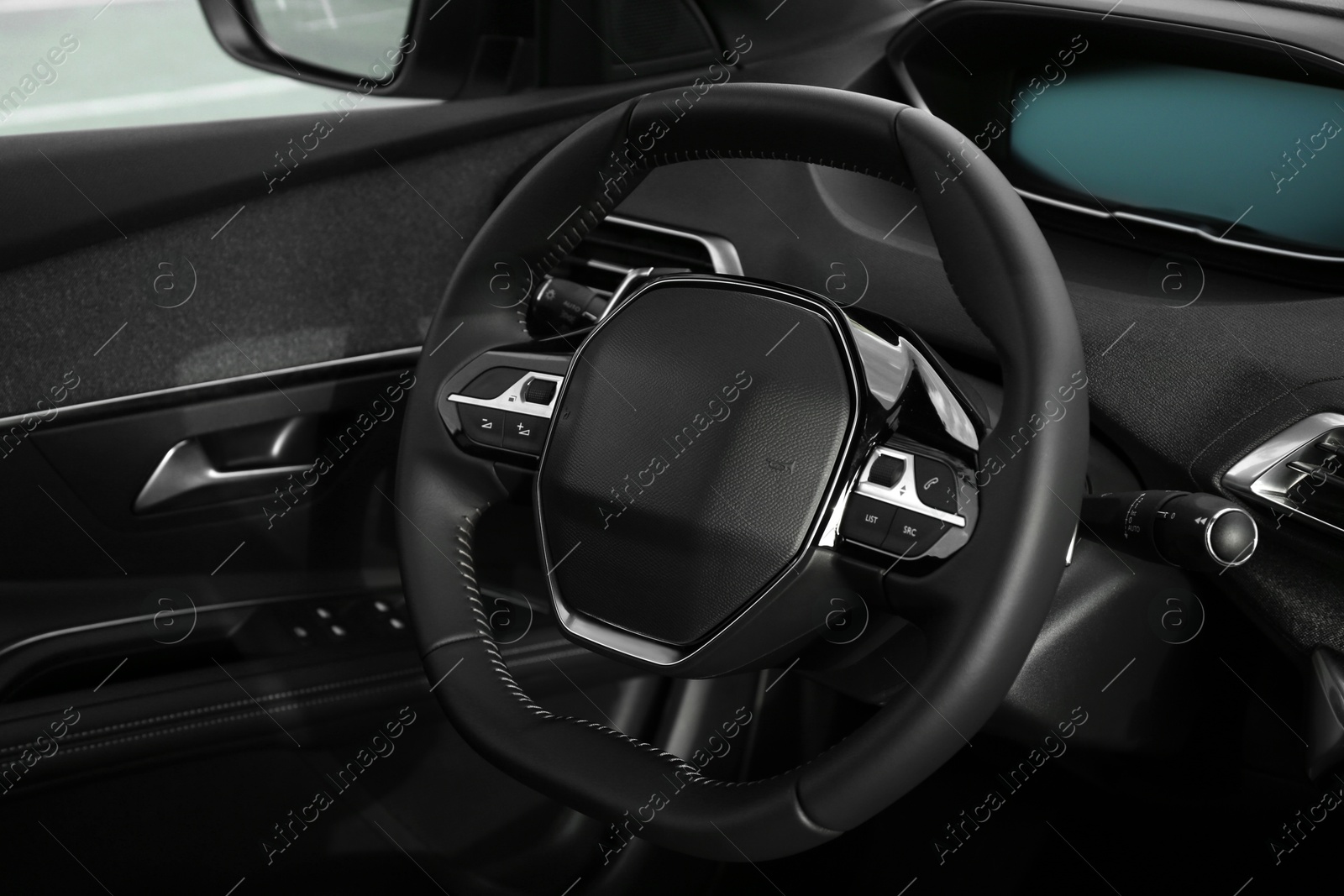 Photo of Steering wheel and dashboard inside of modern luxury car, closeup