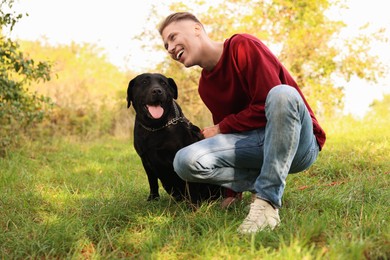 Smiling man with cute dog outdoors on autumn day