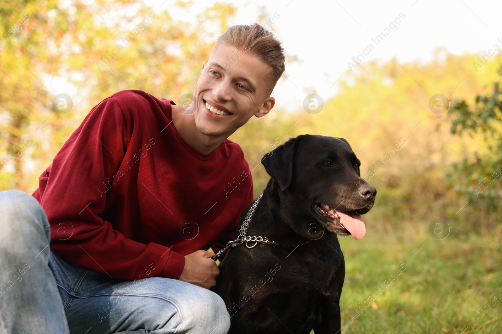 Photo of Smiling man with cute dog outdoors on autumn day