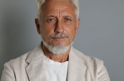 Portrait of senior man on grey background