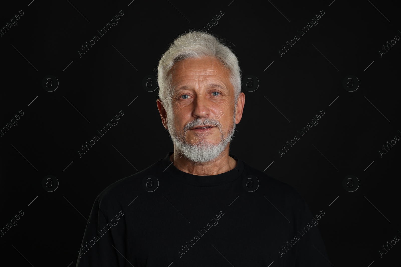 Photo of Portrait of senior man on black background