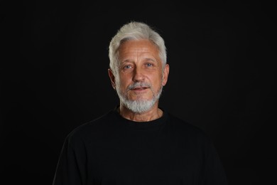 Portrait of senior man on black background