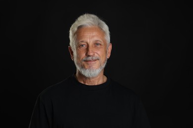 Portrait of senior man on black background