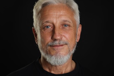 Portrait of senior man on black background