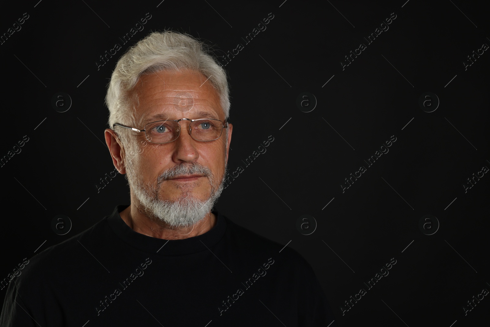 Photo of Portrait of senior man on black background