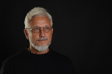 Photo of Portrait of senior man on black background