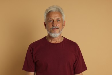 Portrait of senior man on beige background