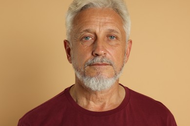 Portrait of senior man on beige background