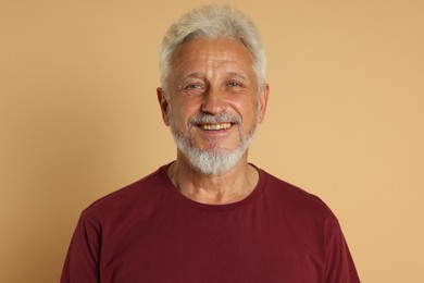 Portrait of senior man on beige background