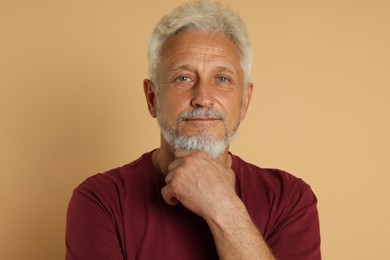 Portrait of senior man on beige background