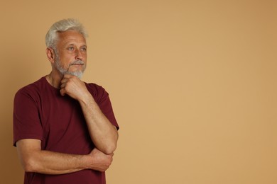 Portrait of senior man on beige background, space for text