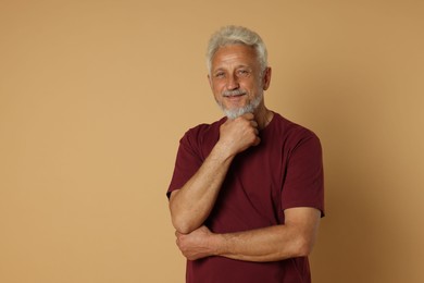 Portrait of senior man on beige background, space for text