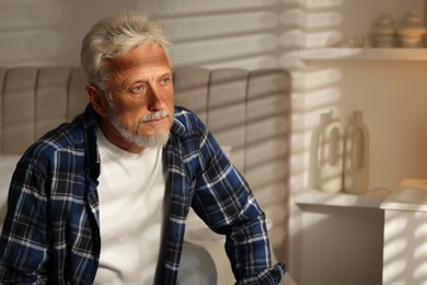 Photo of Portrait of senior man with grey hair at home, space for text