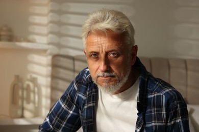 Photo of Portrait of senior man with grey hair at home