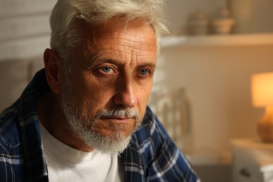 Portrait of senior man with grey hair at home, space for text