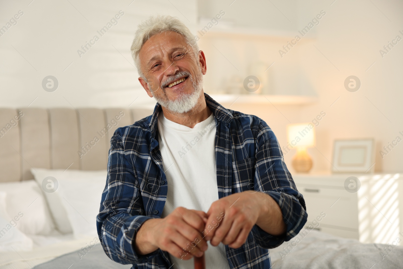 Photo of Senior man with walking cane at home