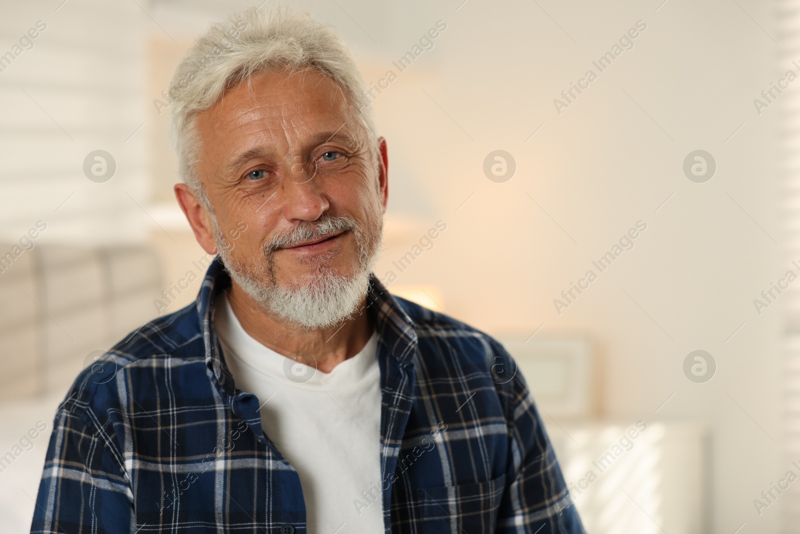 Photo of Portrait of senior man with grey hair at home, space for text