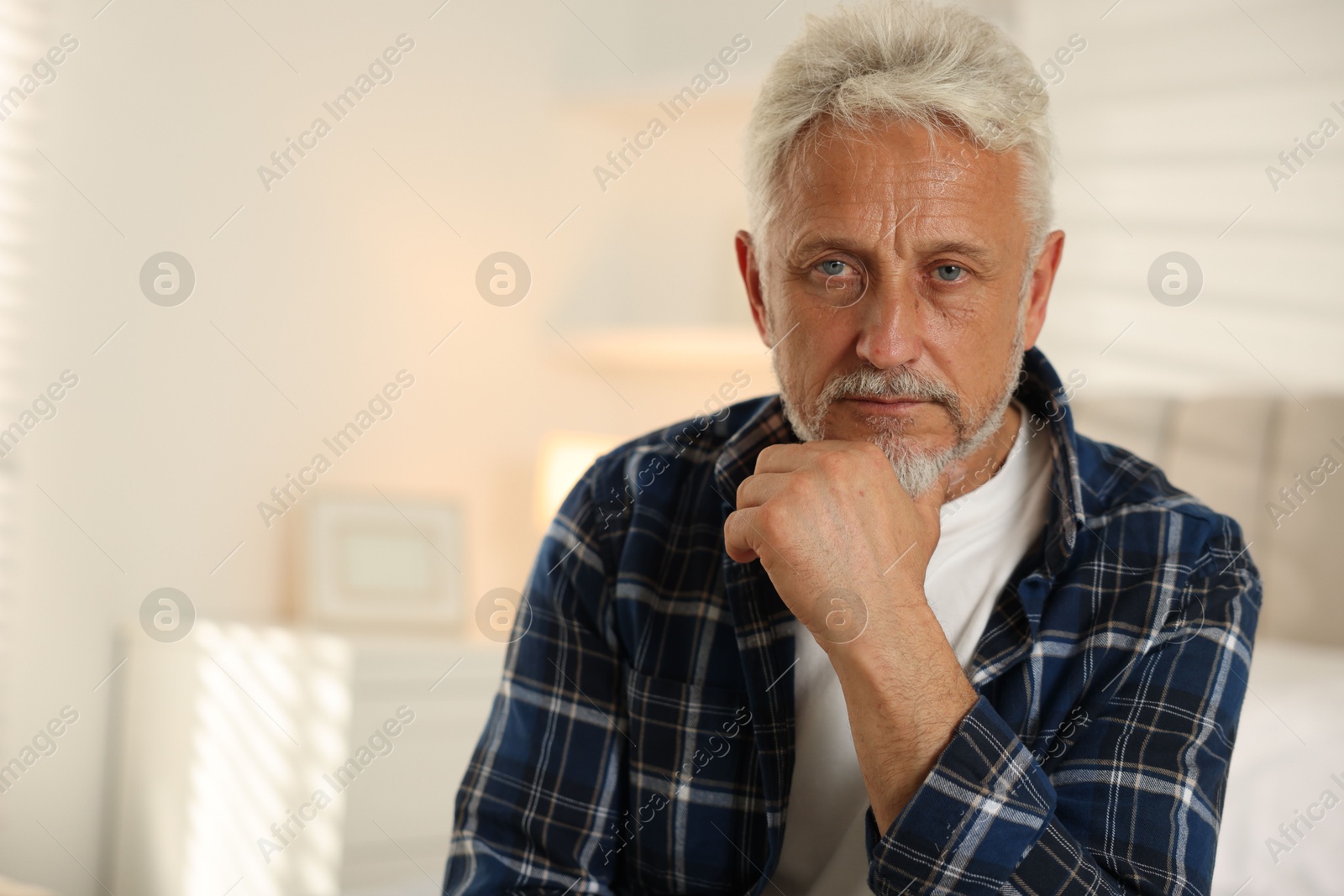 Photo of Portrait of senior man with grey hair at home, space for text