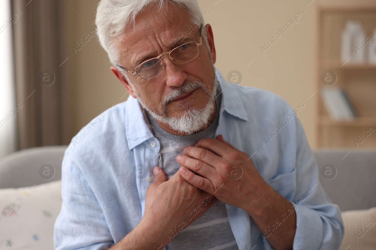 Photo of Senior man suffering from pain in chest at home