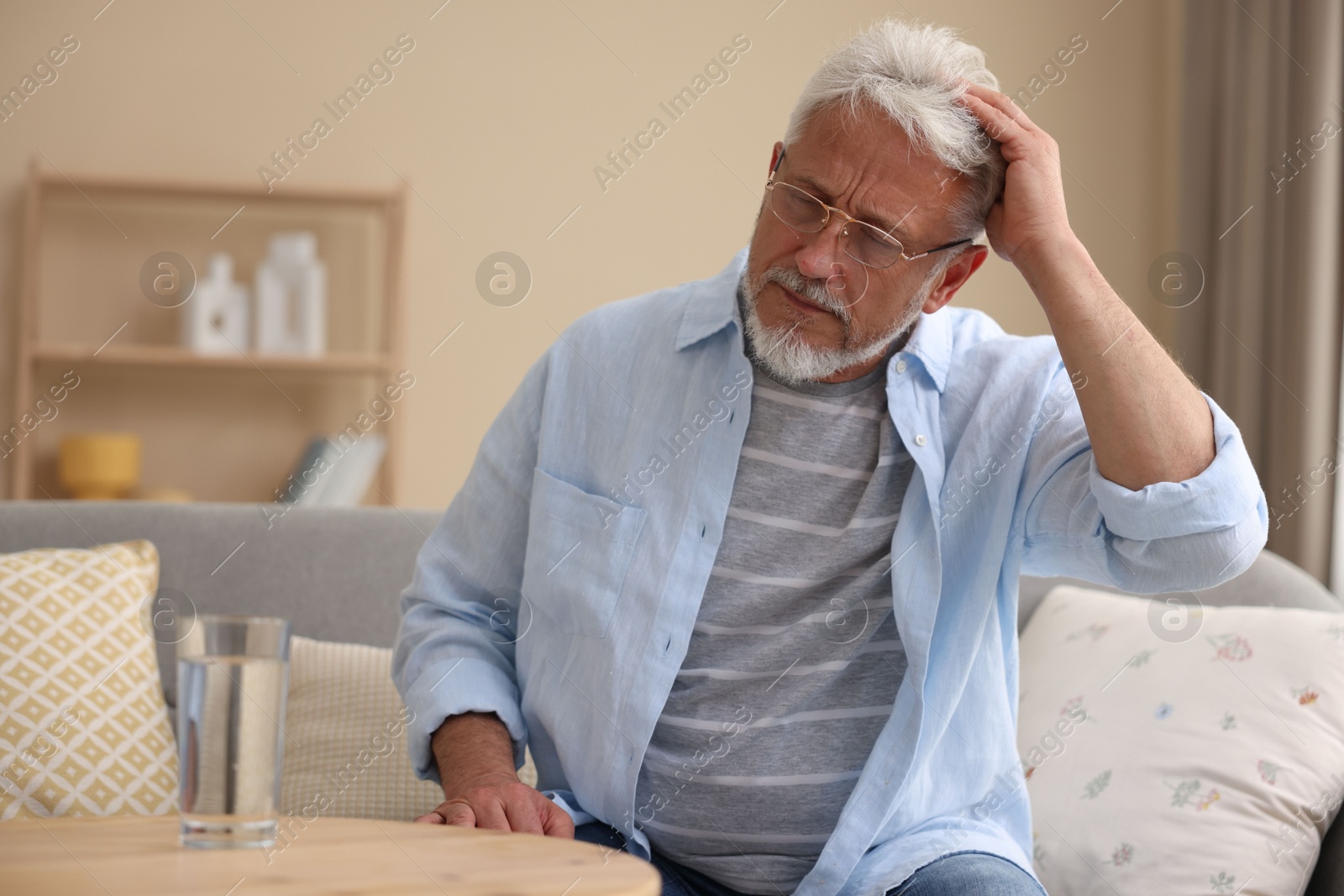 Photo of Senior man suffering from headache at home